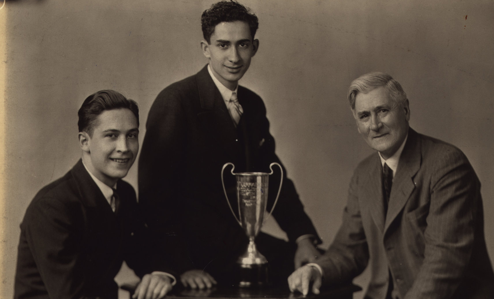 Hon. Robert Sheran (left) was the first recipient of the Distinguished Alumni award. He was on the team that won the Northwest Debate Tournament of 1936, for the College of St. Thomas.  He is shown with Abraham Kaplan and their advisor, Professor Owen McElmeel, and the winner's trophy.