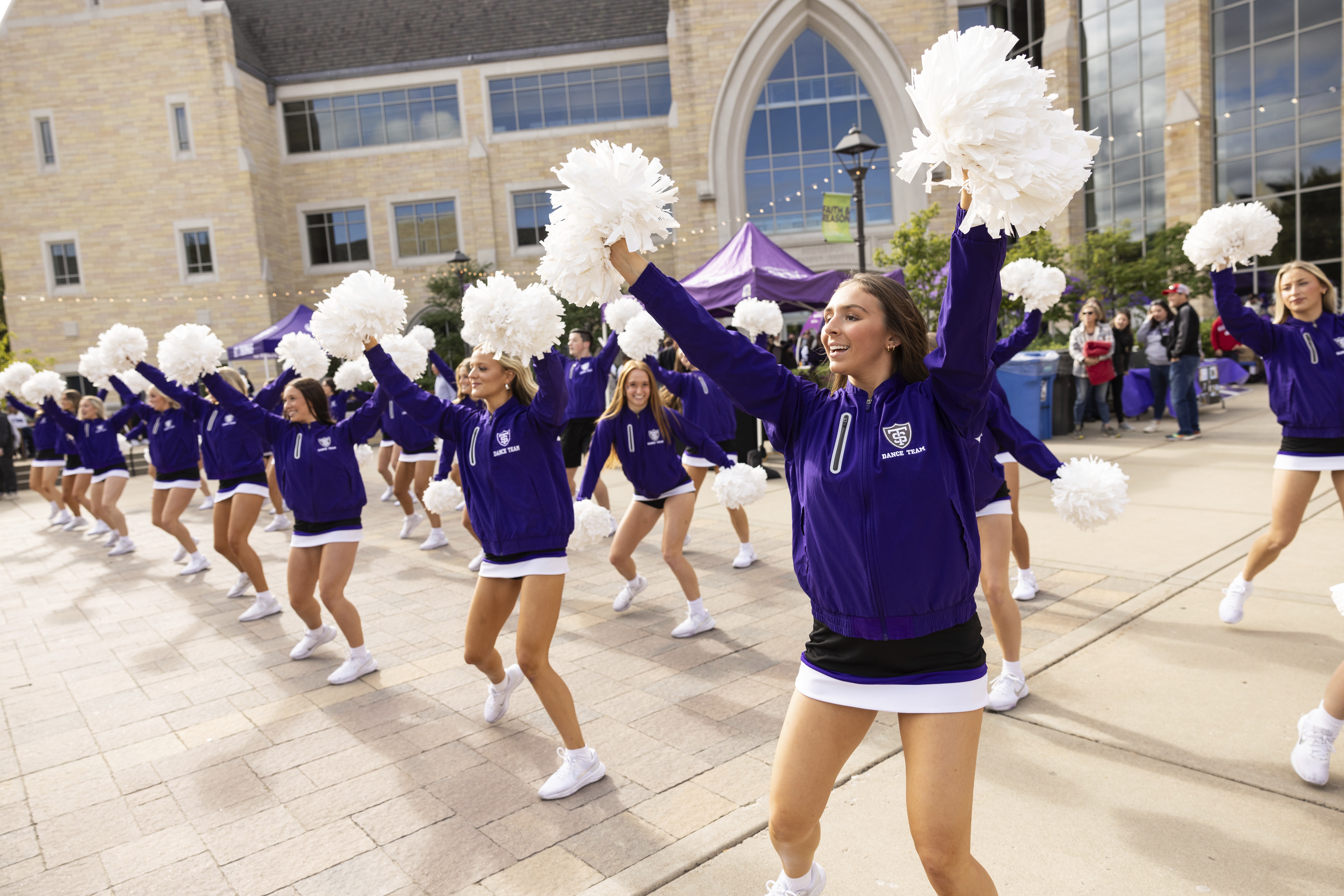 Cheerleaders in front of Anderson Student Center performing for Purple on the Plaza