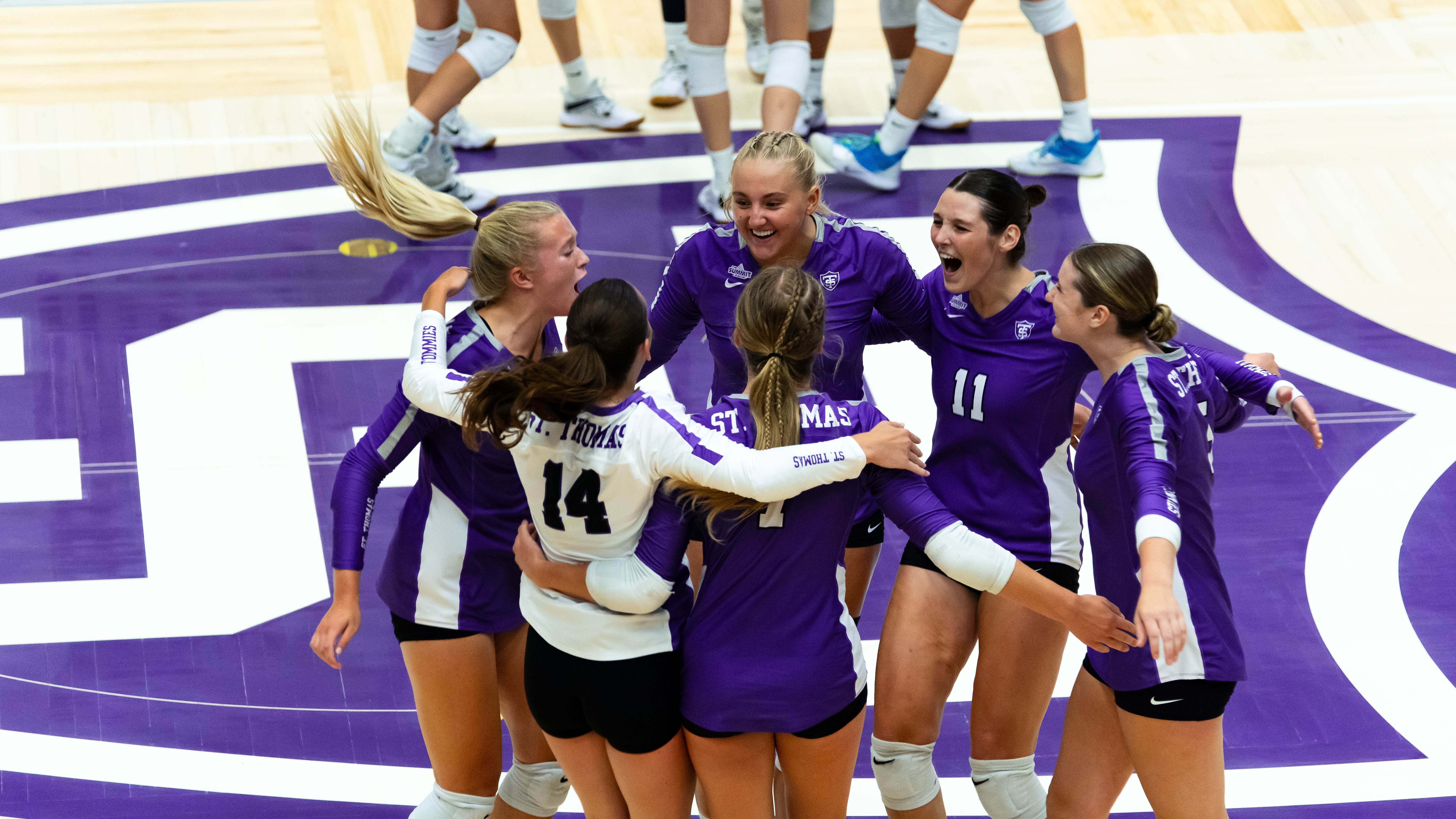 St. Thomas volleyball players celebrating a point during a St. Thomas home game