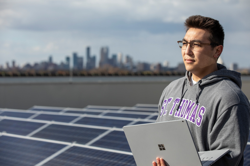 Students looking to the horizon with solar panels and Minneapolis skyline in the background