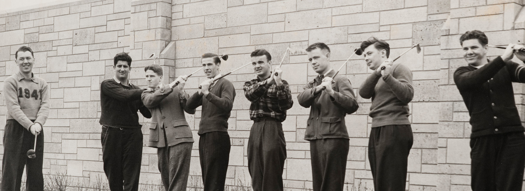   1940-41 Golf team, with Athletic Hall of Fame member coach Tom Hamper (left). "14.09.02 Golf Team, 1941" and "C82-150-643 1941 Athletics Golf - Oversize" and " (l - r) Tom Hamper [Coach - Athletic Hall of Fame member], Samuel Cavellero, Joseph Mahoney, Henry Lahue, Nicolas Kocisko, Pal Johnson, Robert Lindorfer" on verso. Also stamped "Photo by Kaul" on verso. Copied from original 11" x 14" print. Copied on October 28, 2009. This image may not be reproduced for any reason without the express written consent of the Department of Special Collections, University of St. Thomas Libraries, 2115 Summit Avenue, Saint Paul, MN 55105; (651) 962 ? 5467 ; libweb@stthomas.edu. Athletics Hall of Fame. 