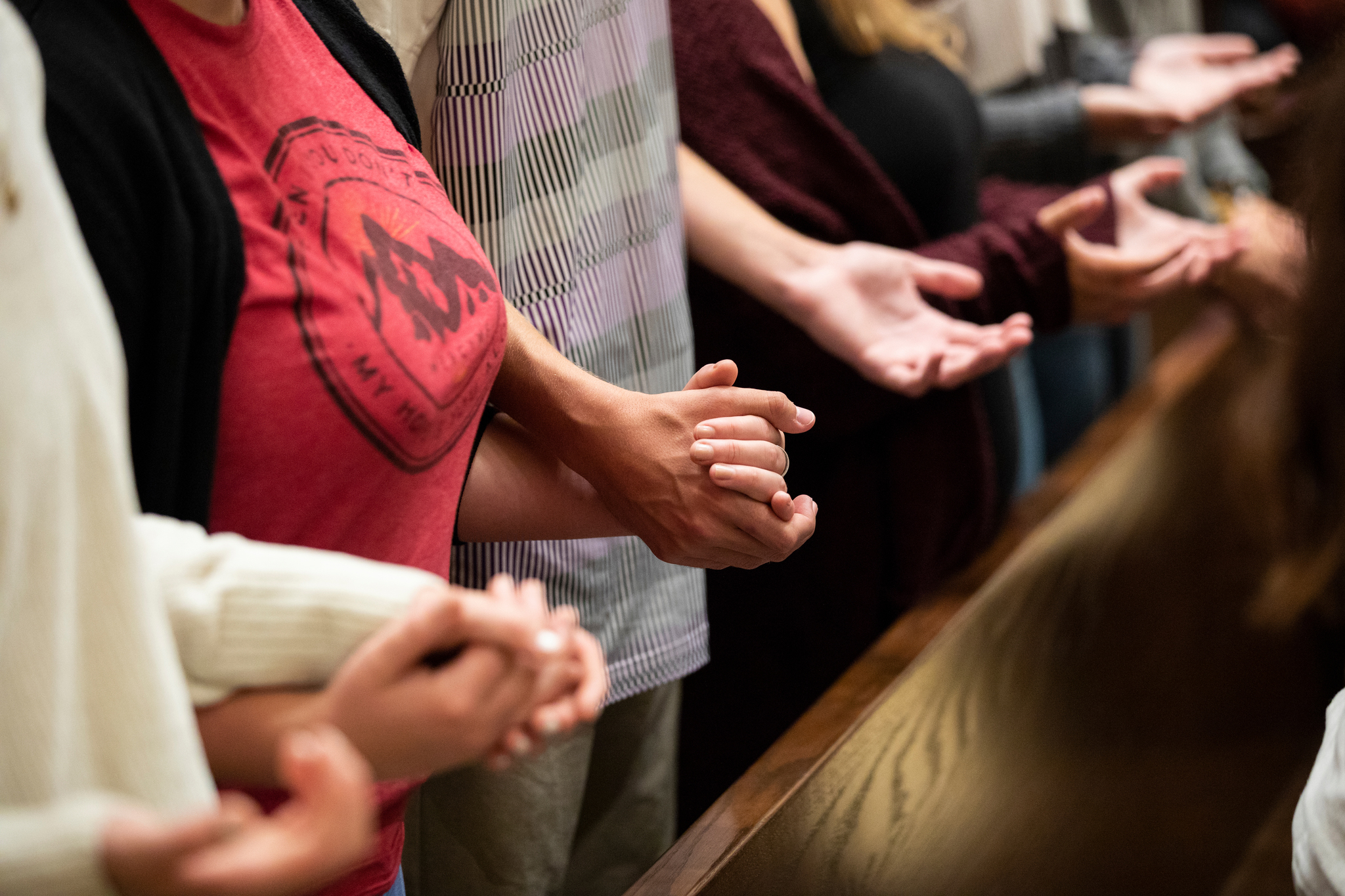 Hands are held together at a worship service on campus