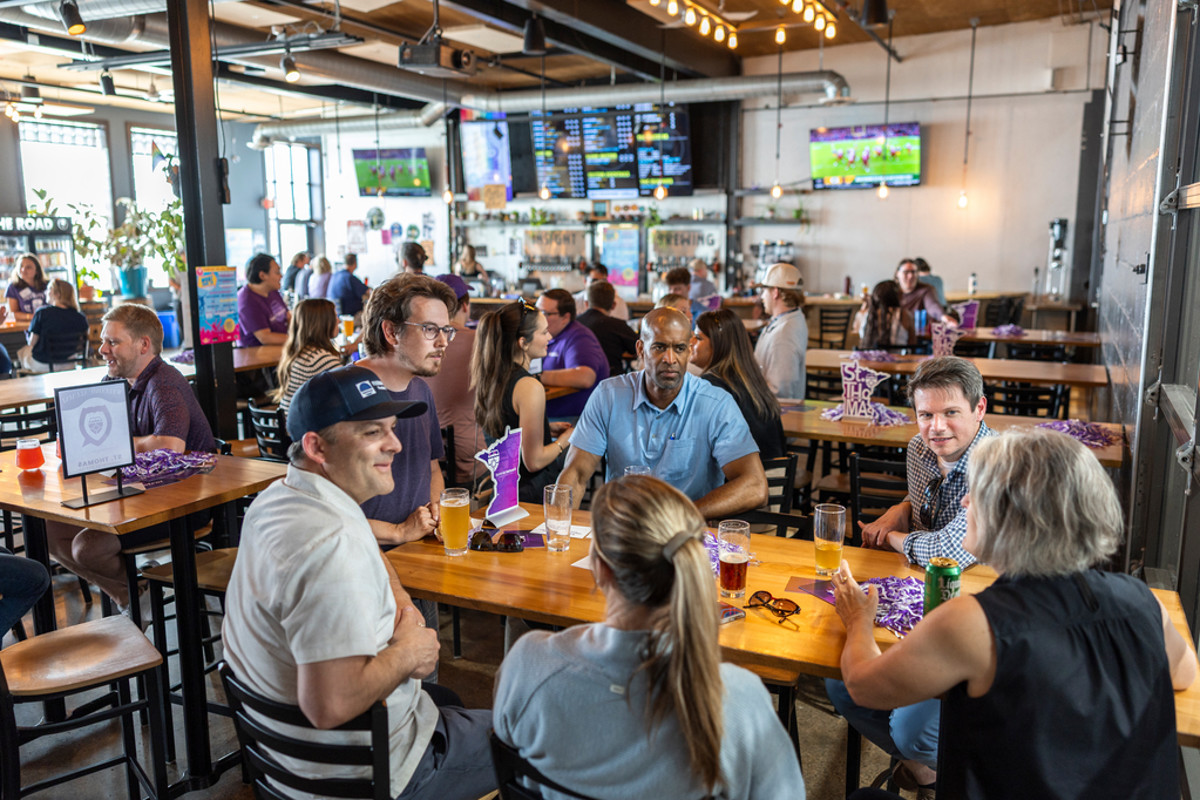 Tommie alumni gathered at a table at Insight Brewing