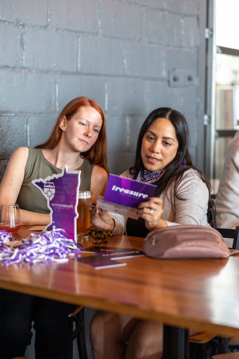 Tommie alumni gathered at a table at Insight Brewing