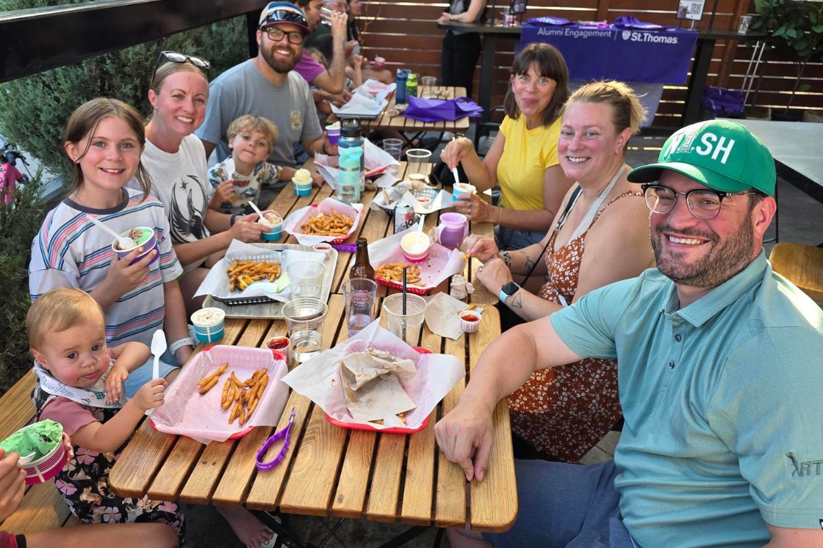 a family sits at a picnic table enjoying ice cream