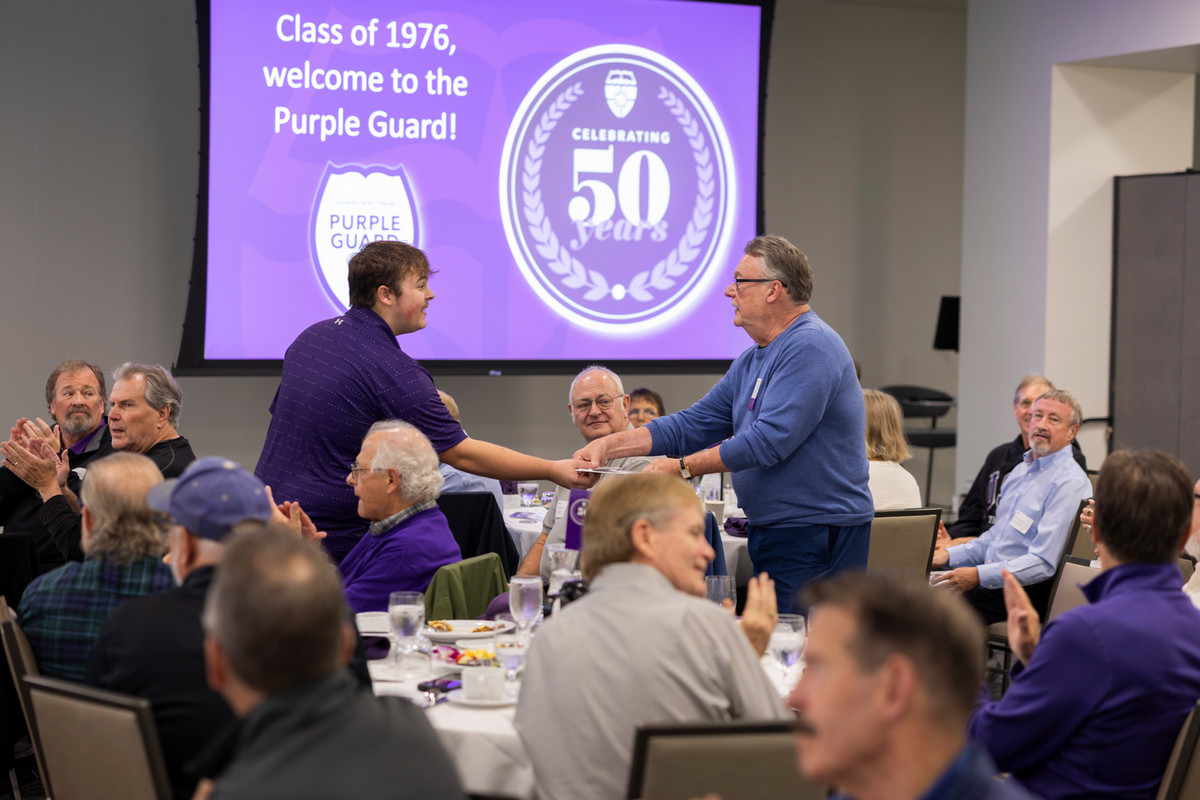 Two Purple Guard members shaking hands