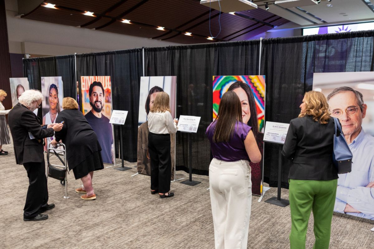 Attendees interact with large photos of honorees