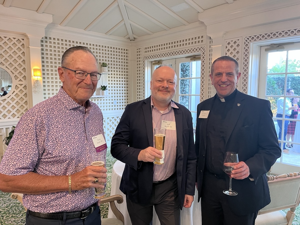 Father Chris poses with two TOTR Naples attendees in the ballroom