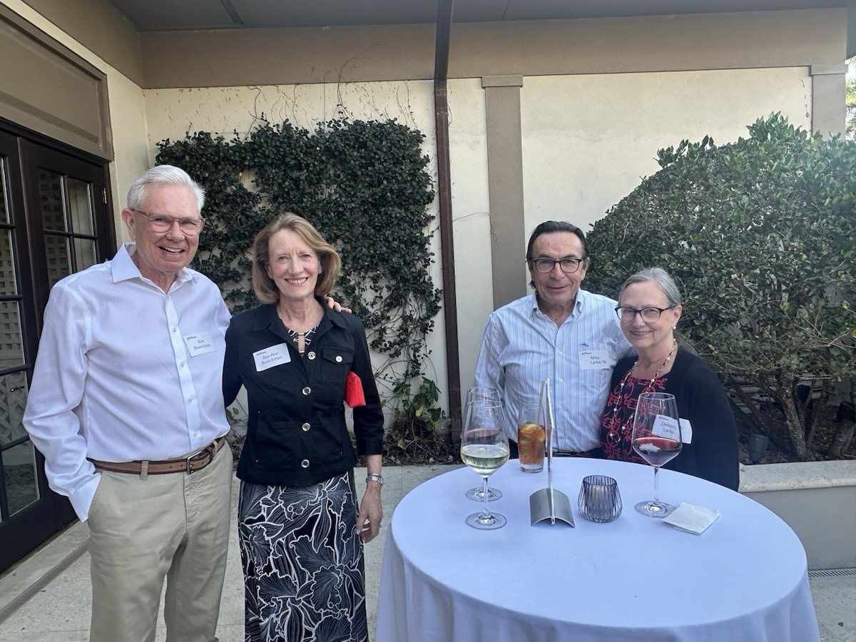 Two couples smile for a photo together on the patio at the Royal Poinciana Golf Club