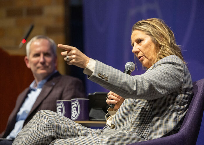 Coach Cheryl Reeve speaks into a microphone and gestures to the audience at Finding Forward in November 2025.