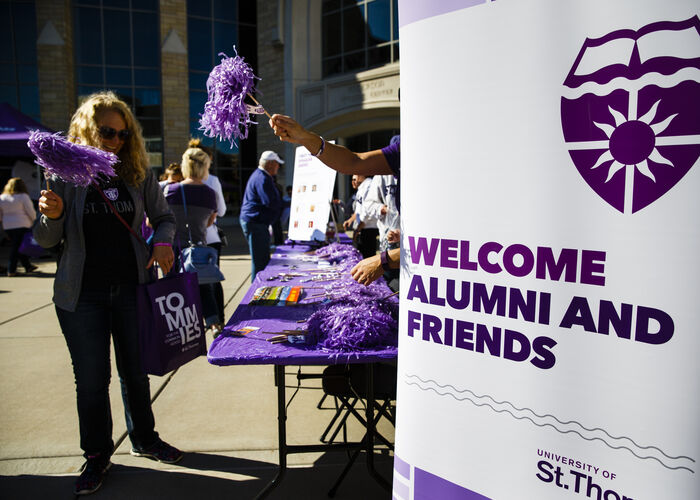 Welcome Alumni and Friends sign at Alumni Engagement table on the plaza during homecoming.