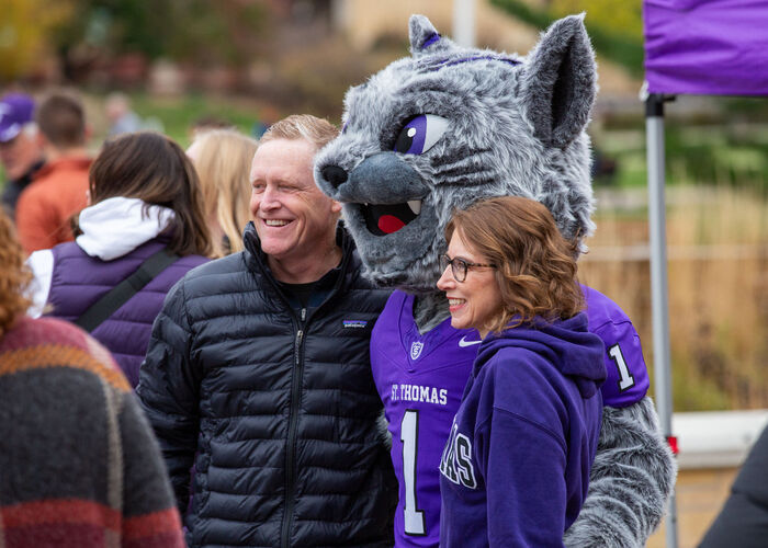 Couple poses with Tommie mascot during Homecoming.