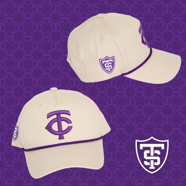 Purple and white St. Thomas Night with the Twins branded hats against a purple background