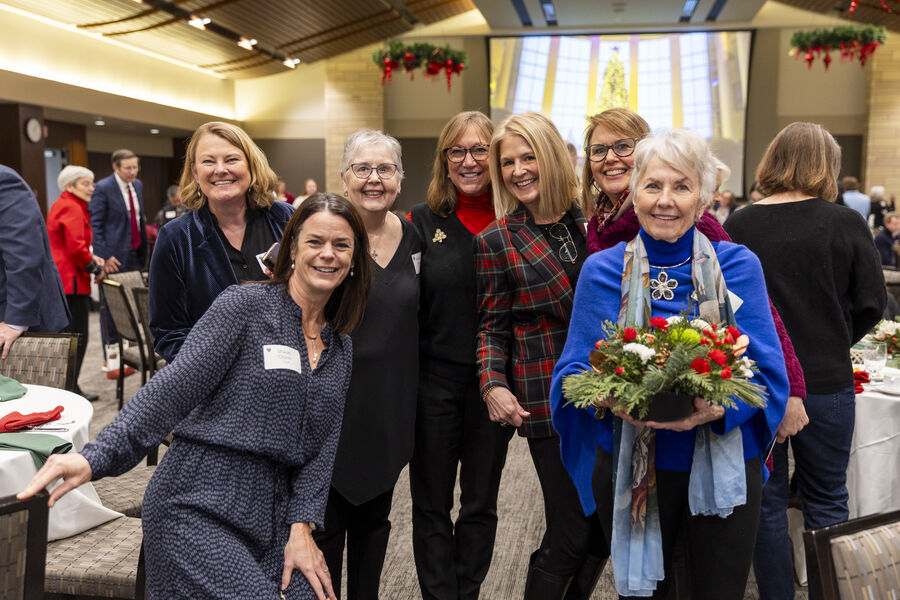 Group of alumni pose for a photo in James B. Woulfe Alumni Hall during the Christmas luncheon.