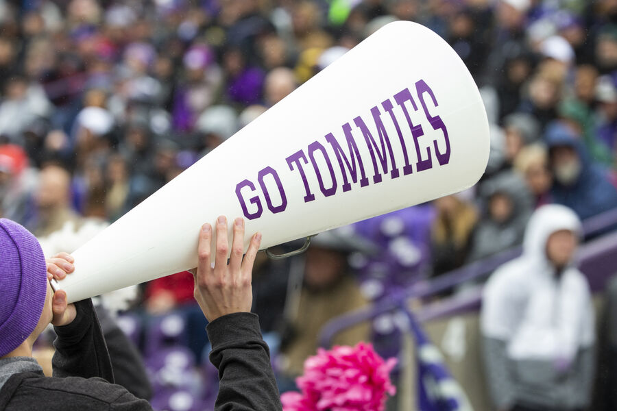 Person shouting in Tommies megaphone to rally the crowd on game day.