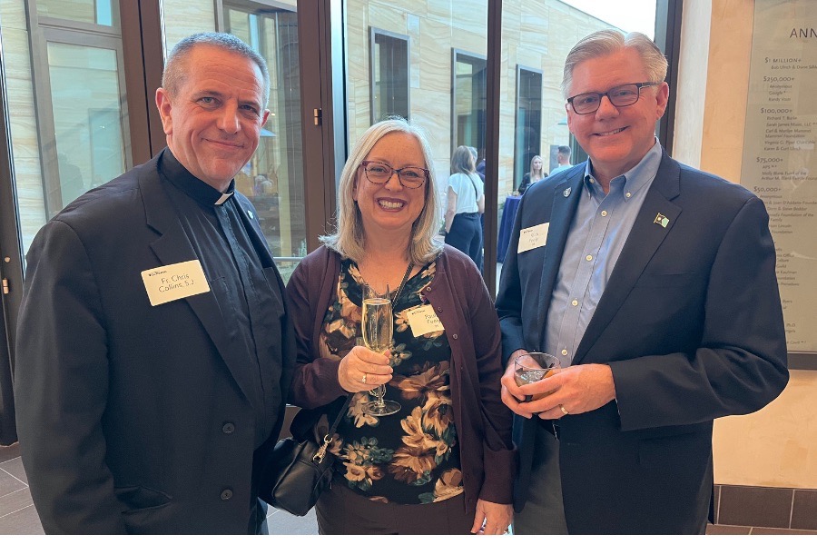 Father Chris smiles for a photo with two TOTR attendees.