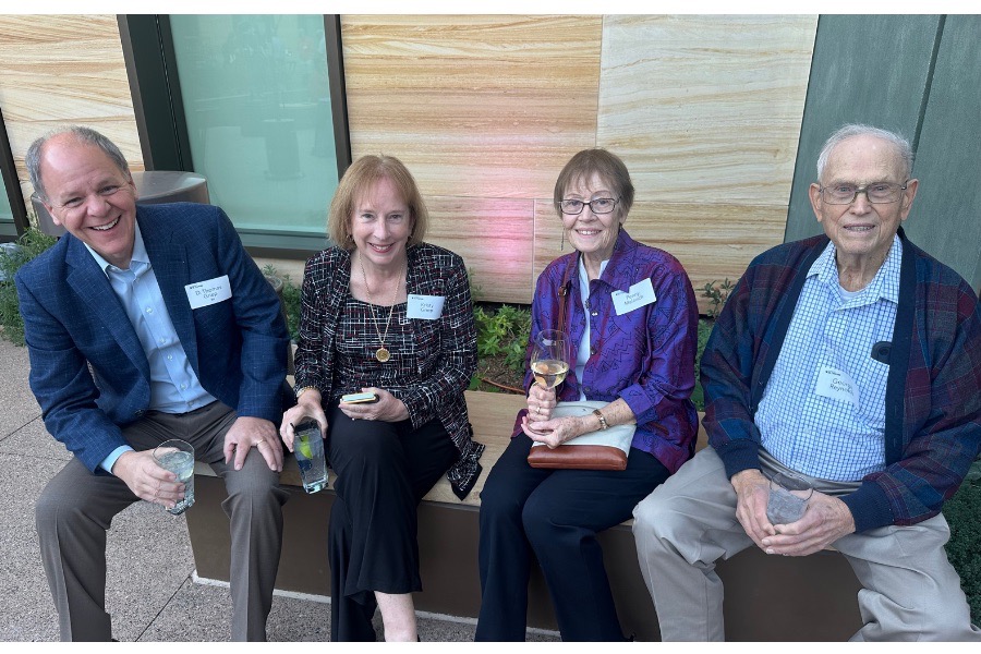 TOTR Phoenix attendees smile for a photo while seated on a bench in the  courtyard at the Musical Instrument Museum.