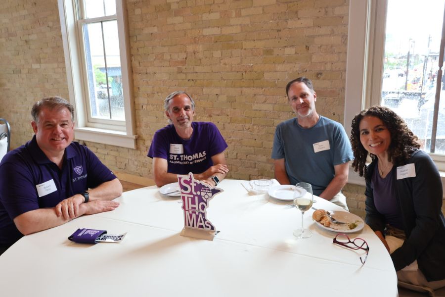 Tommies sitting at a table at Central Standard Crafthouse and Kitchen smile into the camera
