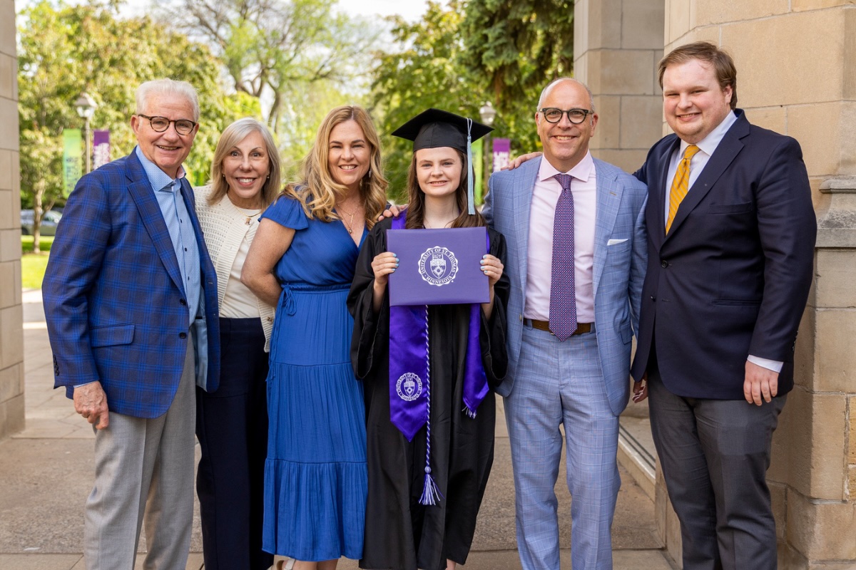 A family of a Morrison College of Health Student stand beneath the Arches on graduation day with their graduate