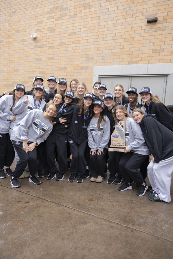 Tommie volleyball team lined up outside of the Arches being welcomed after their Summit League championship win