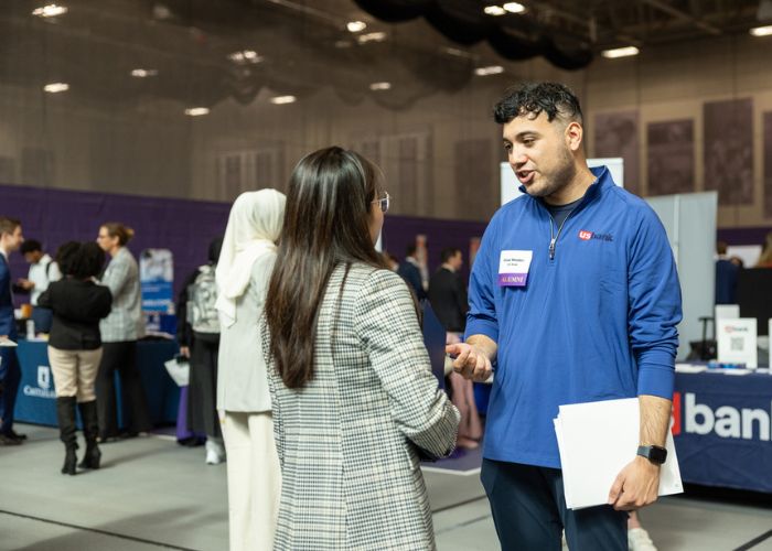 Student talks with St. Thomas alum during on campus career fair.