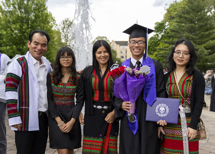 Students pose for a photo with friends and family on the quad after the Undergraduate Ceremony for College of Arts & Sciences