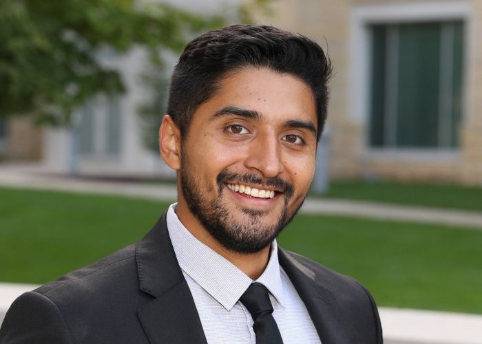 Julián Ocampo ’16, ’18 MBA smiles into the camera for a portrait taken outside of Anderson Student Center
