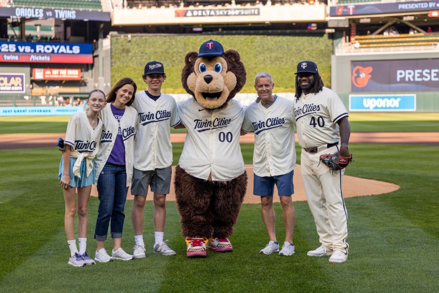 Phil Esten and his family pose with a MN Twin and TC Bear at Target Field. 