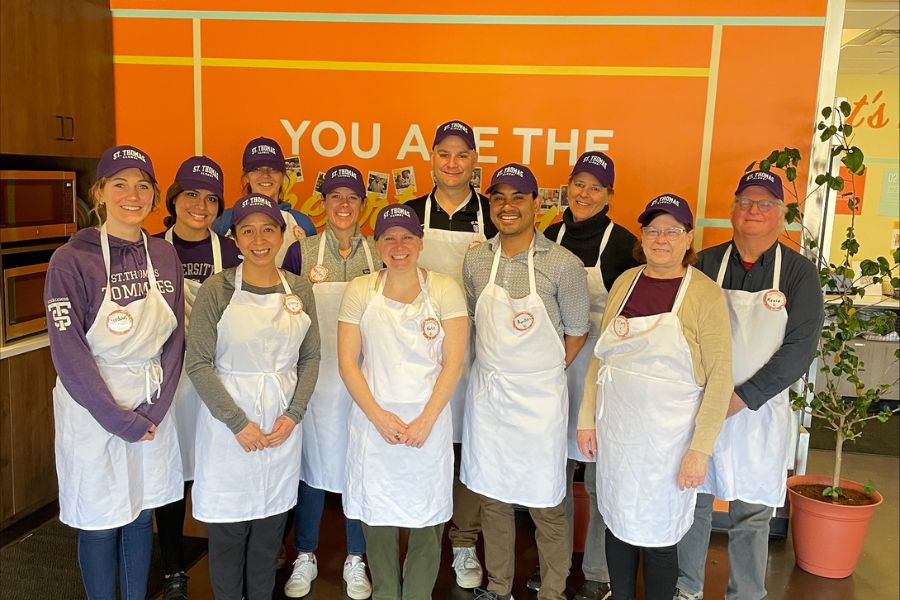 St. Thomas alumni wearing aprons and ready to volunteer at Second Harvest. 