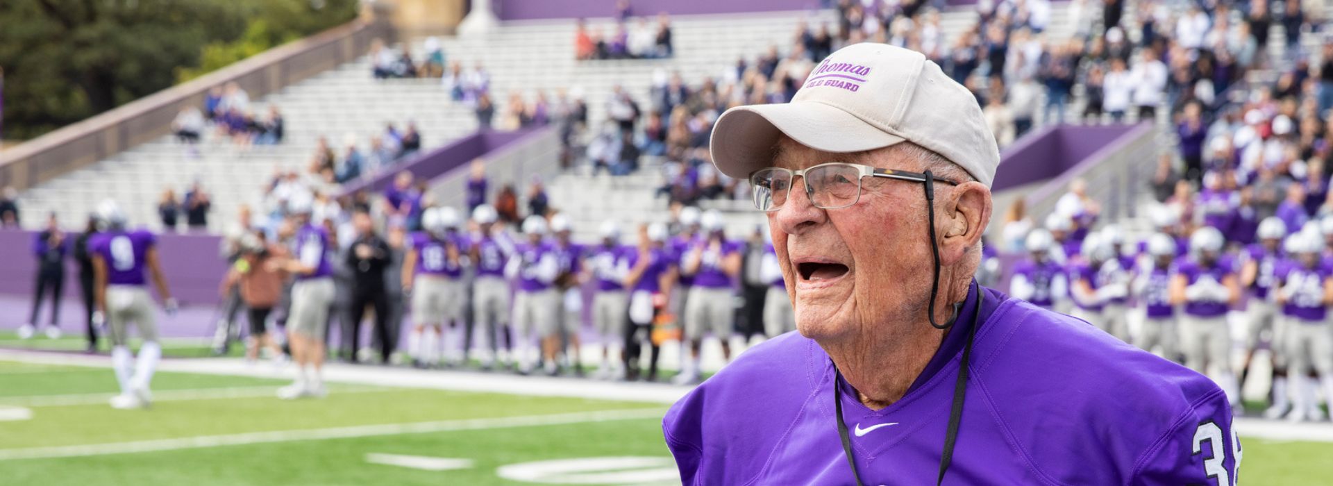 Tom Pacholl smiling on the field at a Tommies football game