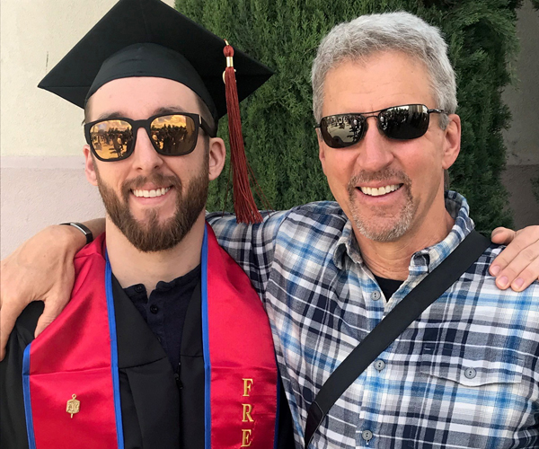 Tom Smith is pictured with his son after his college graduation