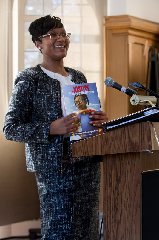 Dr. Artika R. Tyner is pictured holding her book during a speaking engagement at St. Thomas.