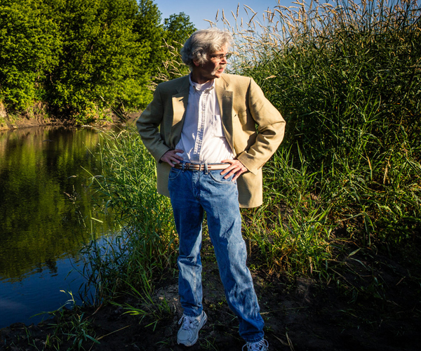 Art Cullen stands at the edge of a river for a portrait
