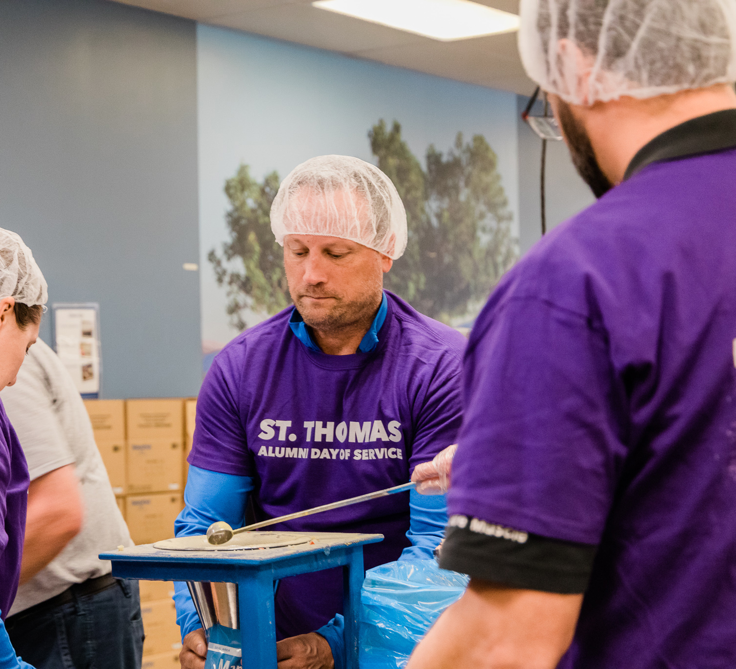 3m employee pours grain during a volunteer session at feed my starving children