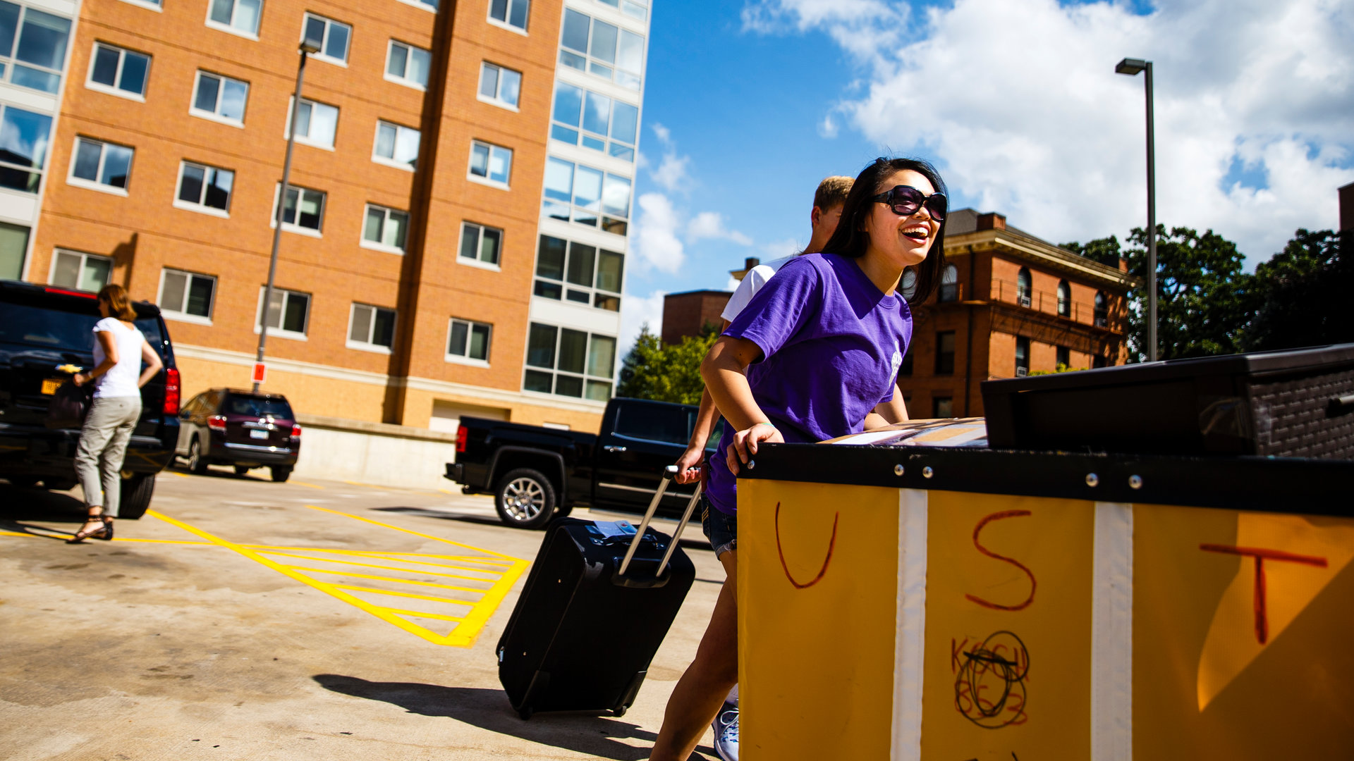 student pushing move in crate in front of flynn hall